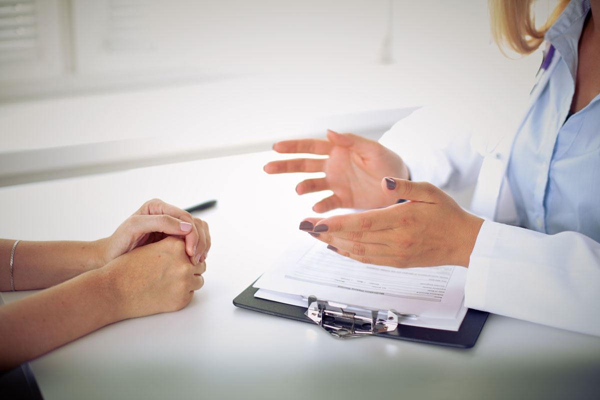 doktor-und-patient-diskutieren-etwas-nur-haende-am-tisch